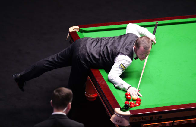 Mark Allen (left) plays a shot towards the reds and the black over the pocket during his match against Yize Wu.