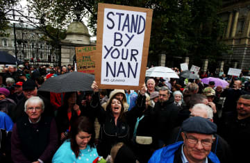 A woman holds a sign during a protest by pensioners outside Leinster House in 2014.